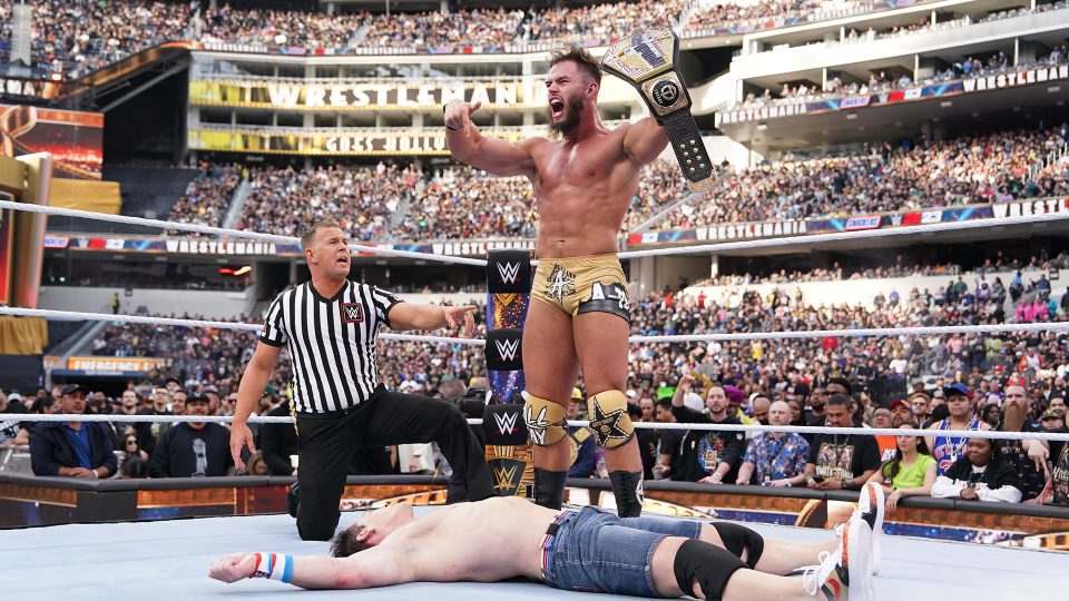 Austin Theory stands over John Cena at WrestleMania 39